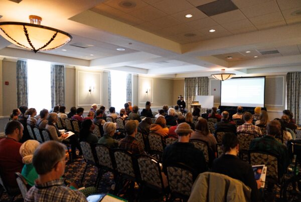 Audience listening to a presentation in a conference room.