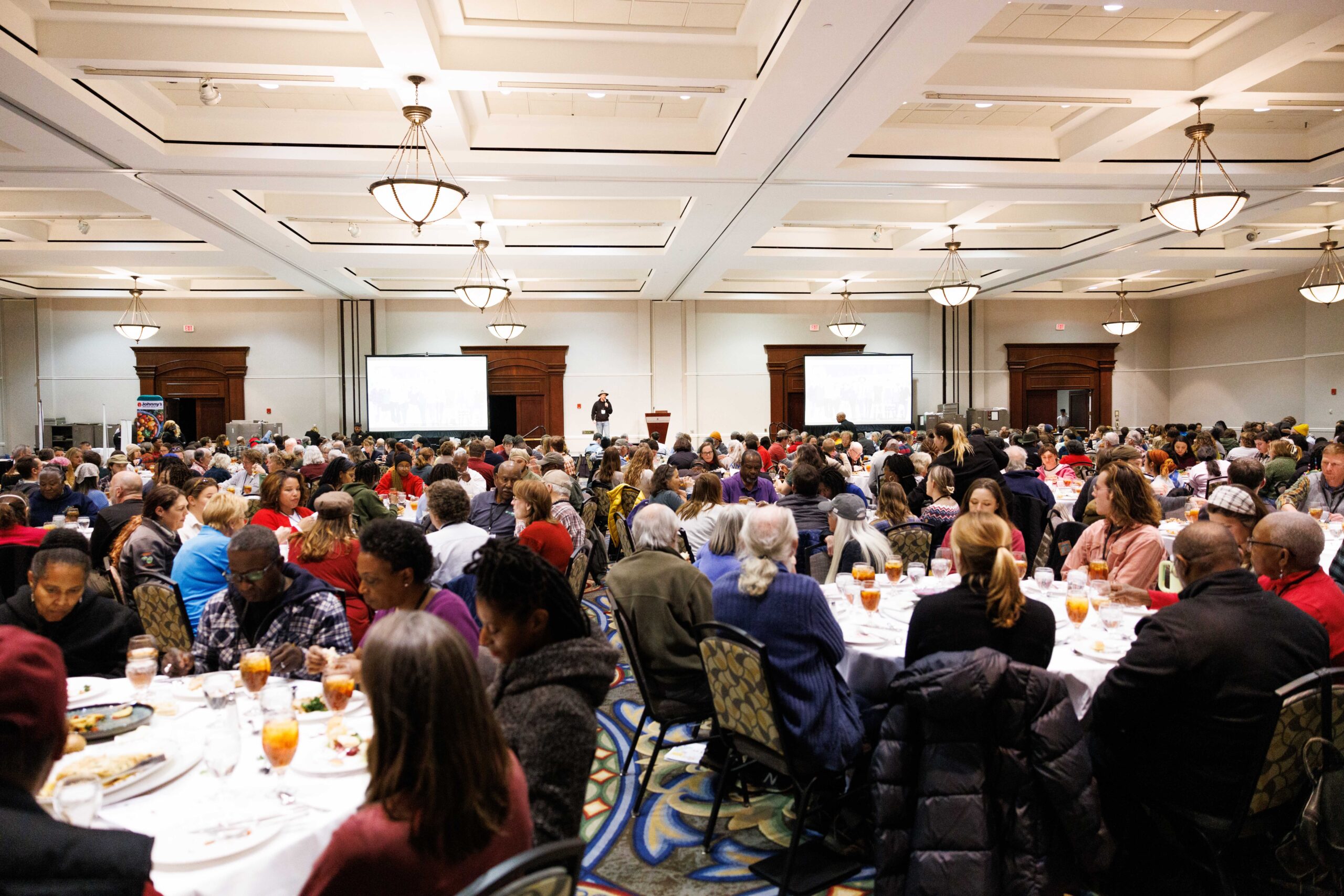 A large group of people attending a formal event in a decorated banquet hall.