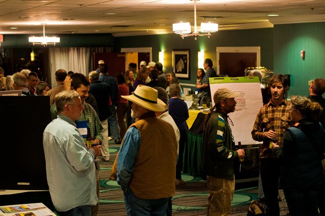 People socializing at an indoor event in a warmly lit room.