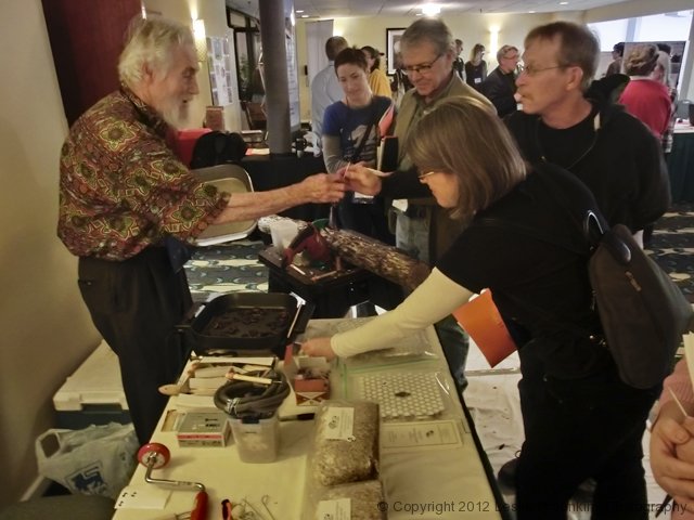People enjoying a food tasting event with servers and attendees.