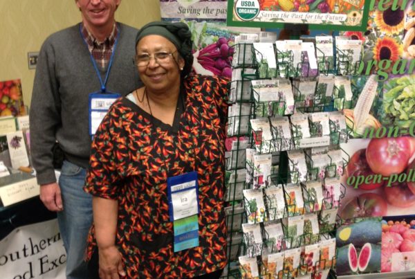 Two people standing near a seed exchange display at an event.