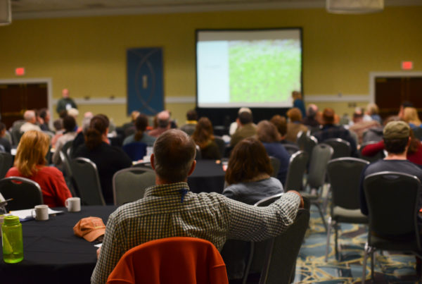Audience watching a presentation in a conference room.