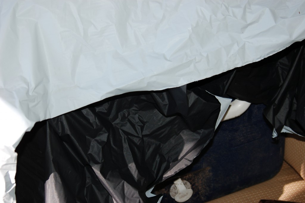 A black and white plastic bag on a dark surface with a white object nearby.