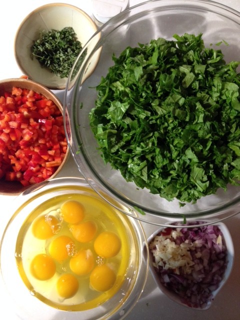 Bowls of chopped vegetables and eggs on a kitchen counter.