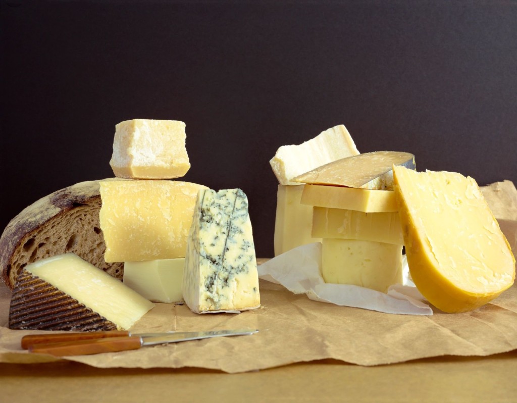 Various types of cheese displayed on paper.