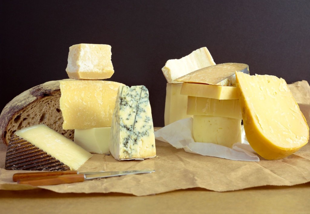 Various types of cheese arranged on parchment paper.