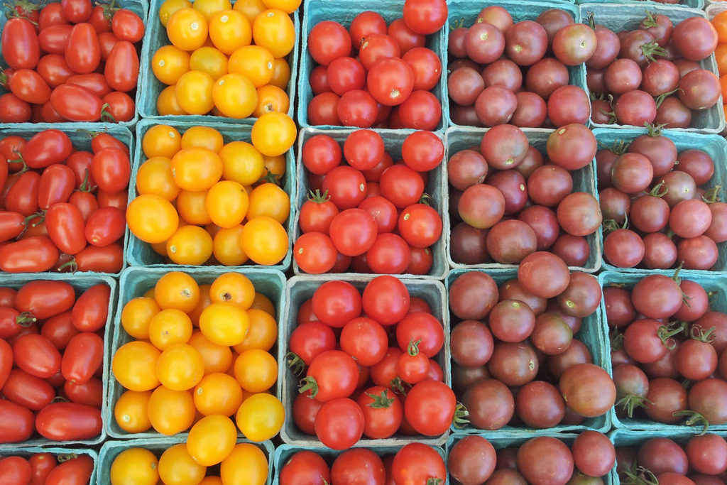 Boxes of assorted cherry tomatoes in various colors.