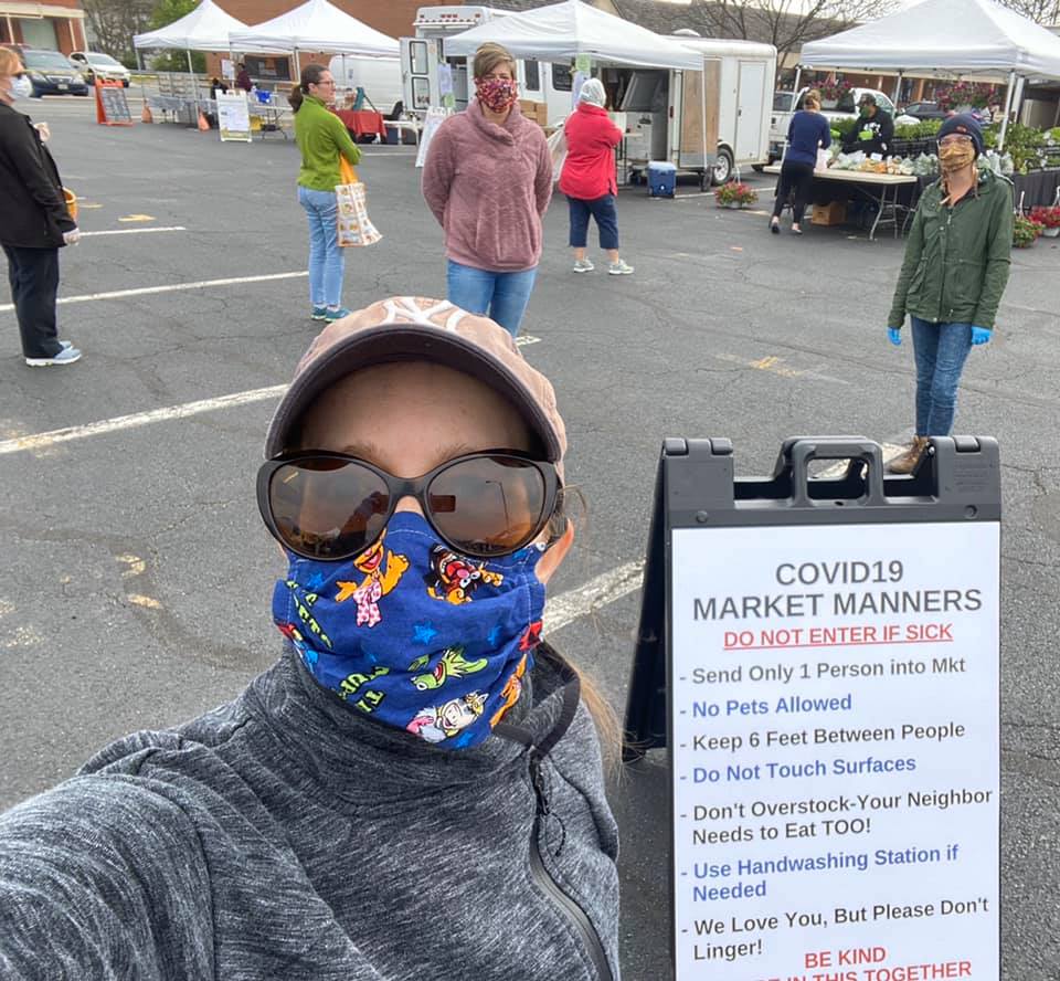 A sunflower held by two outlined hands inside a circular frame.