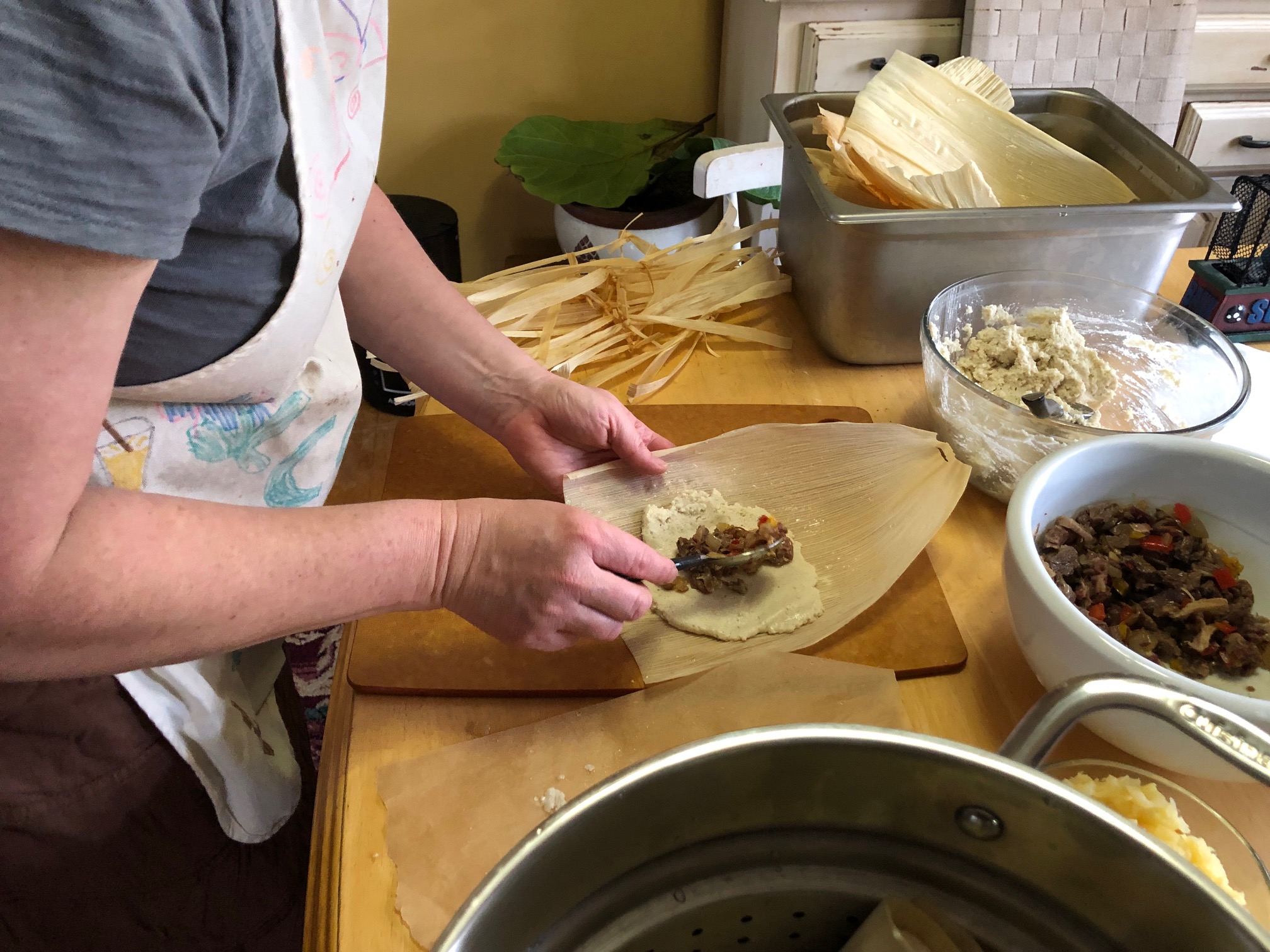 Person preparing dumplings by hand at a kitchen counter.